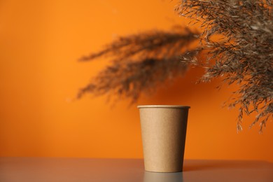 Photo of Paper cup on grey table indoors. Mockup for design