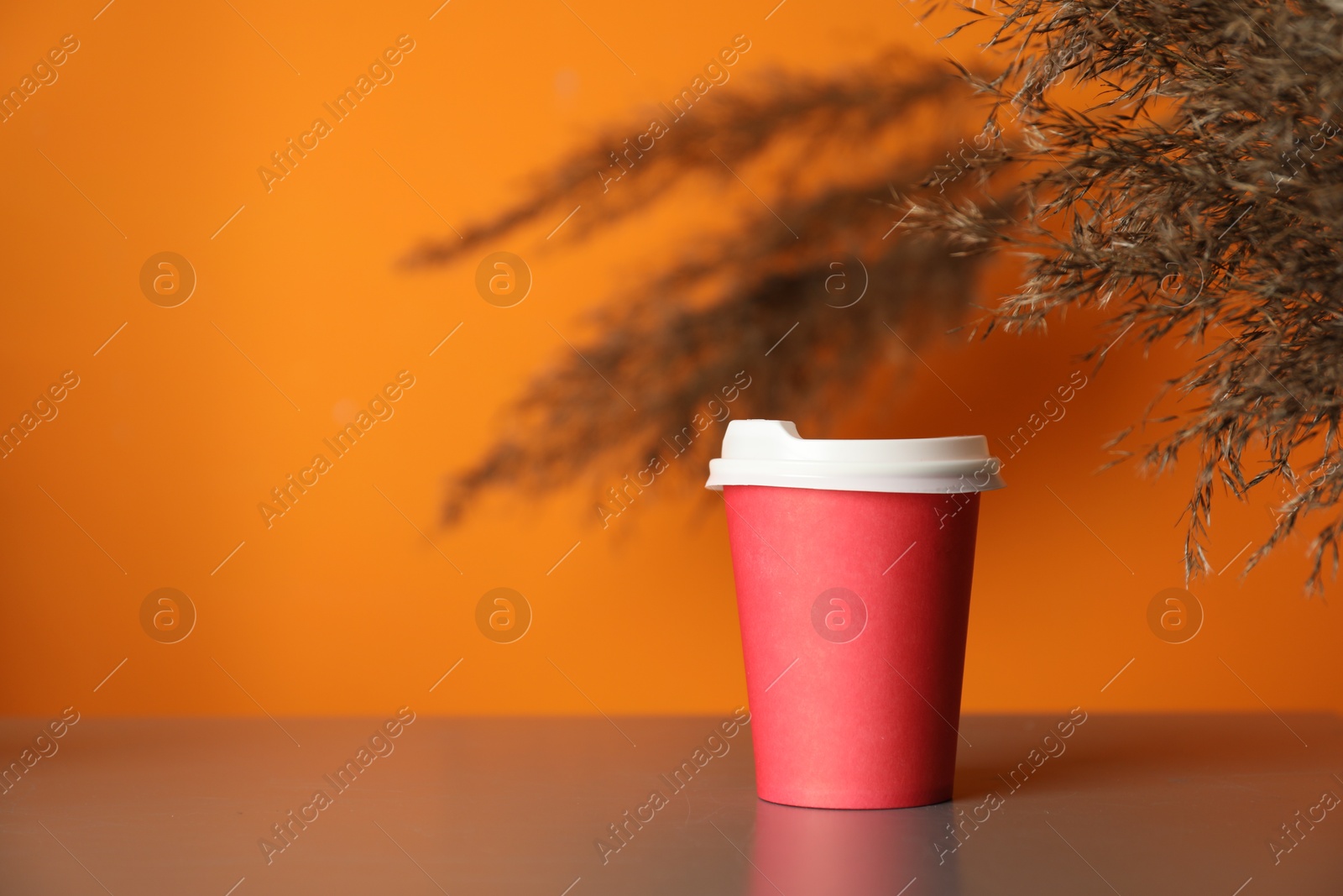 Photo of Paper cup on grey table indoors. Mockup for design