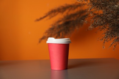 Photo of Paper cup on grey table indoors. Mockup for design