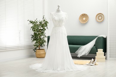 Photo of Beautiful wedding dress on mannequin and shoes in boutique