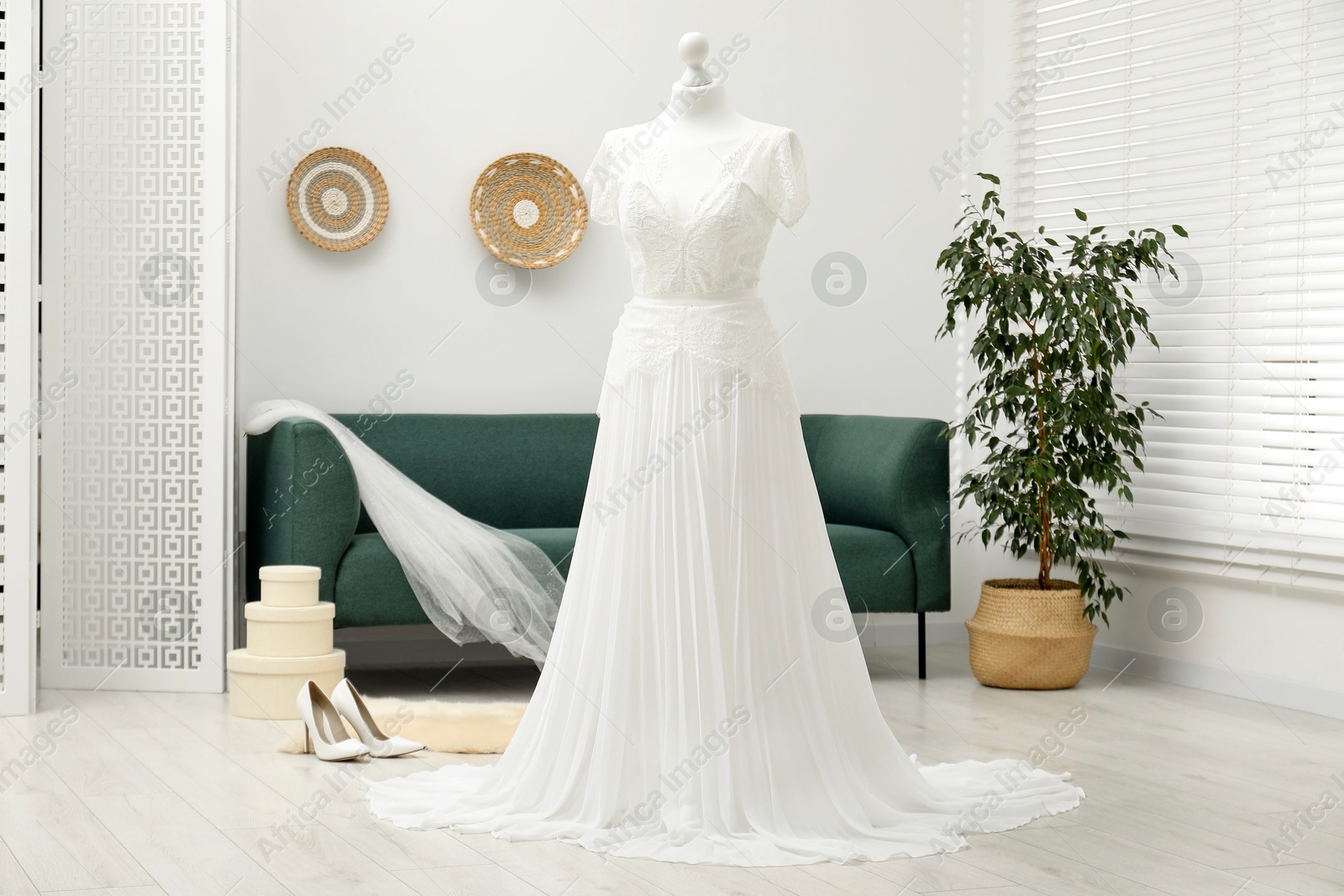 Photo of Beautiful wedding dress on mannequin and shoes in boutique