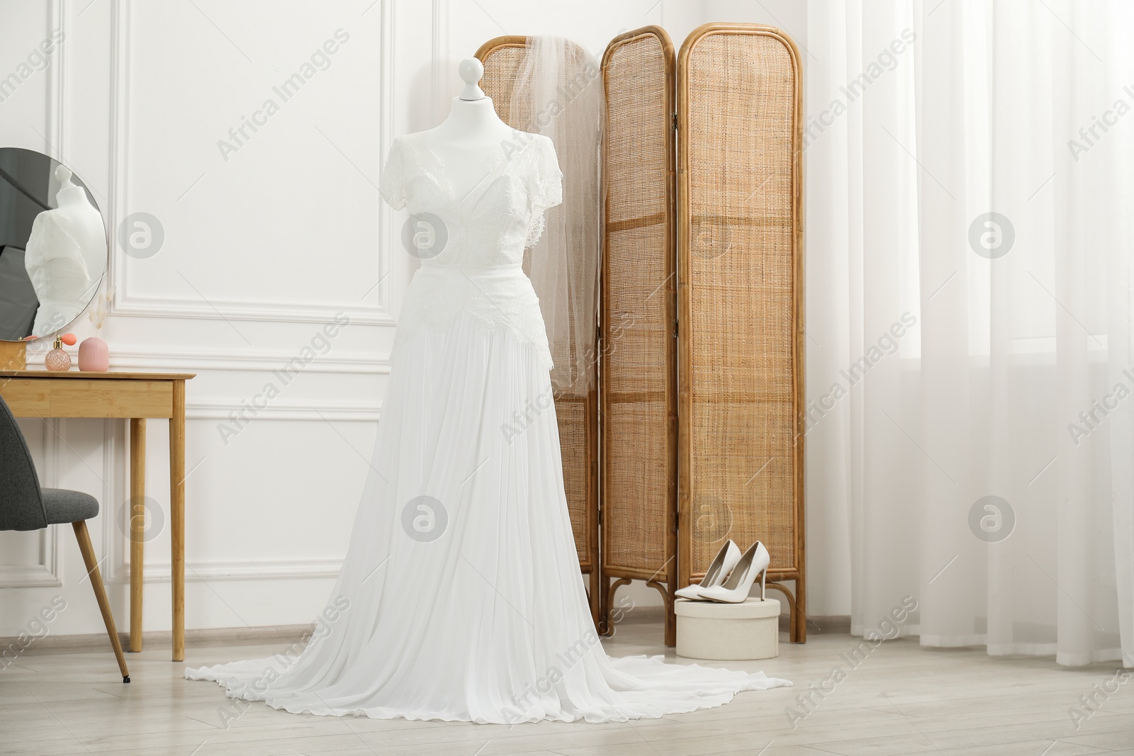 Photo of Beautiful wedding dress on mannequin and shoes in boutique