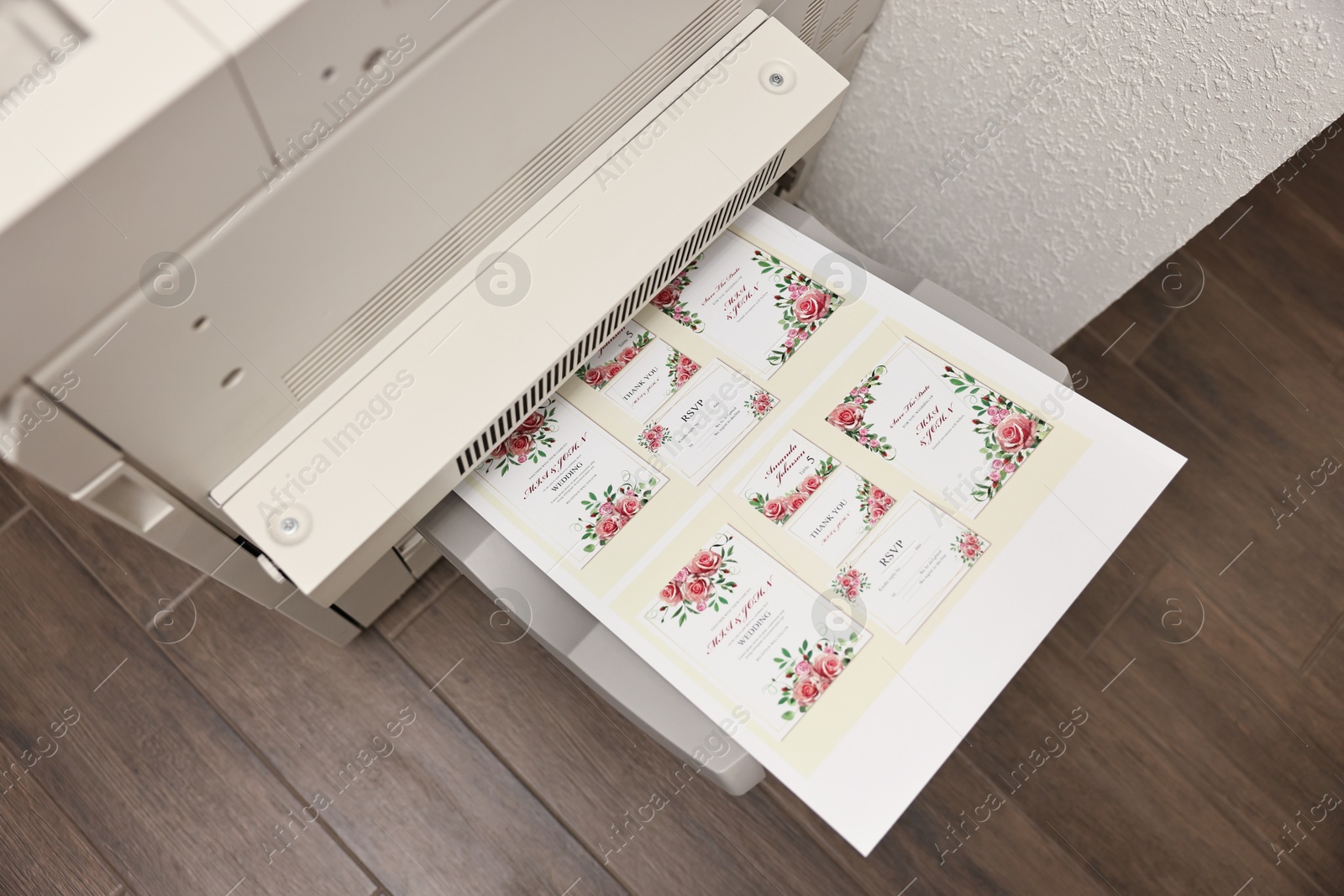 Photo of Modern printer with printed wedding invitation cards indoors, above view. Printing house