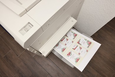 Photo of Modern printer with printed wedding invitation cards indoors, above view. Printing house