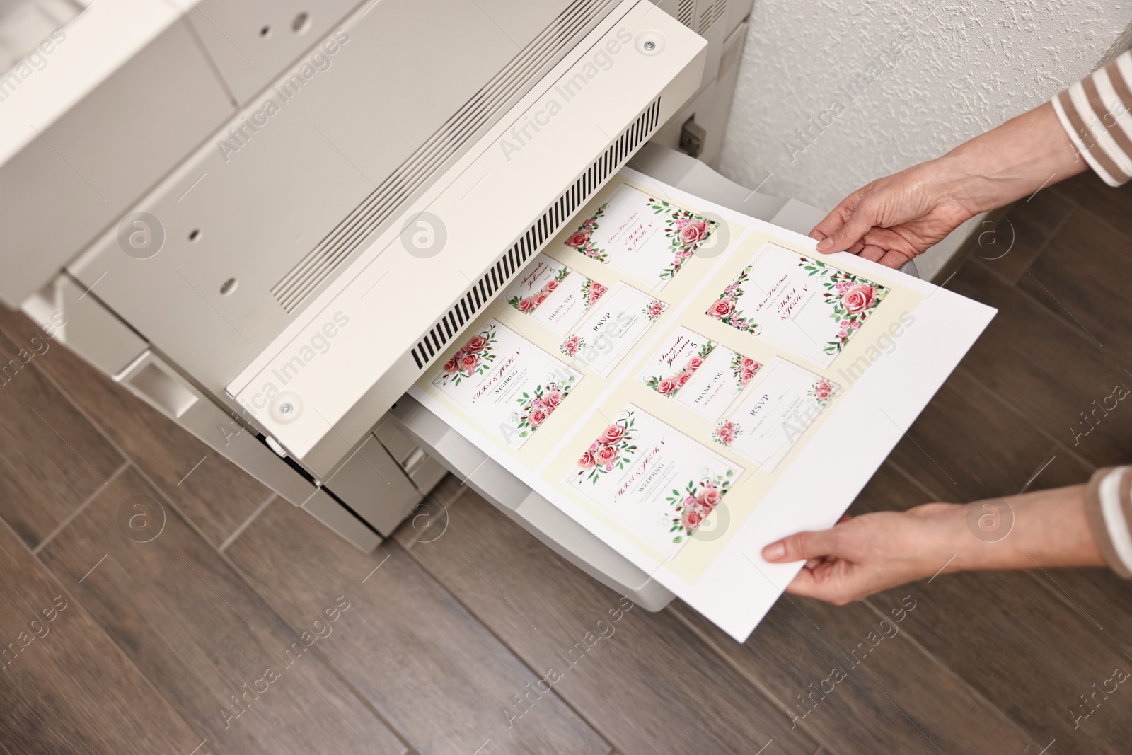 Photo of Woman using modern printer indoors, above view. Printing house