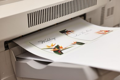 Photo of Modern printer with printed wedding invitation cards, closeup. Printing house