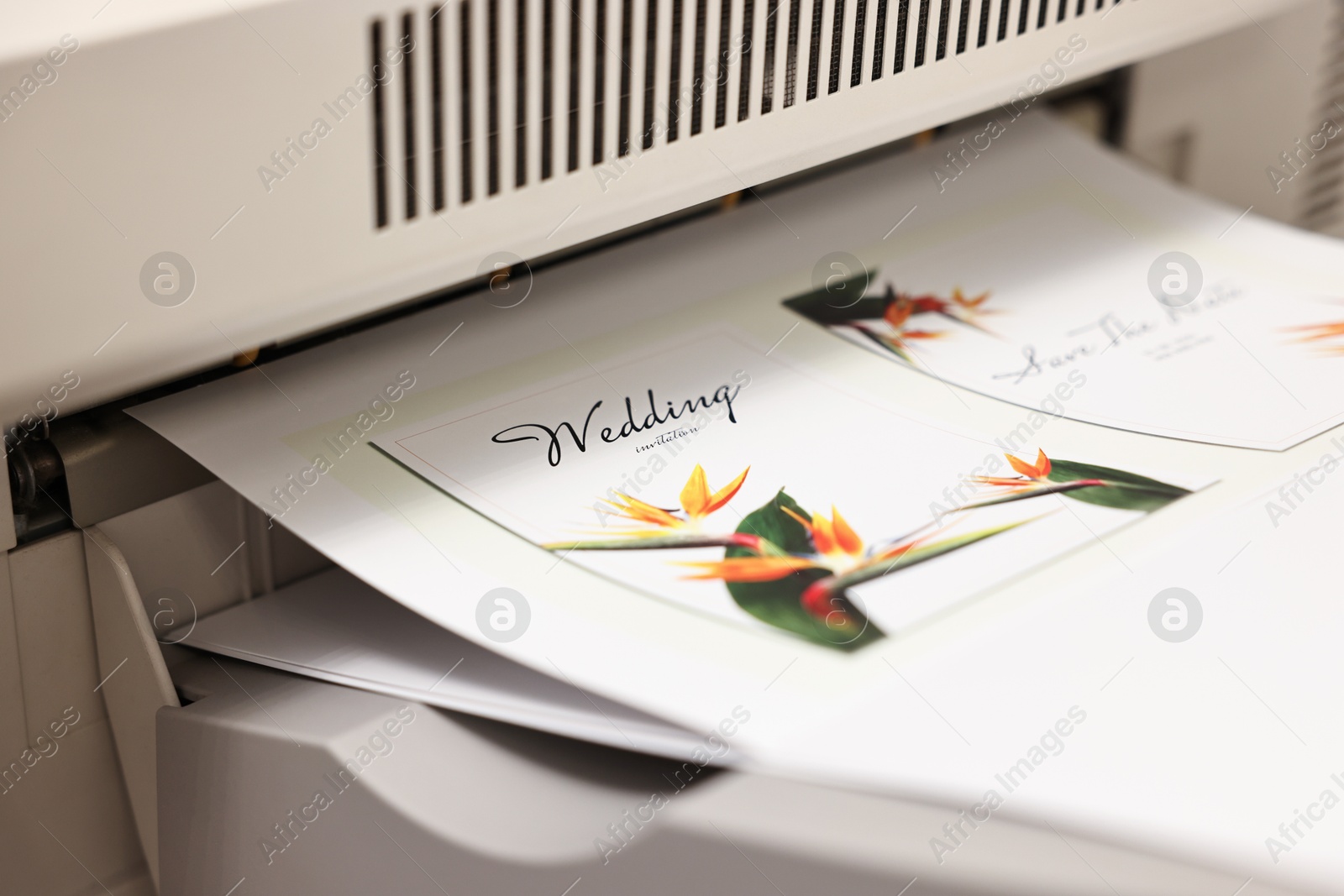 Photo of Modern printer with printed wedding invitation cards, closeup. Printing house