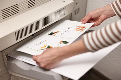 Photo of Woman using modern printer indoors, closeup. Printing house