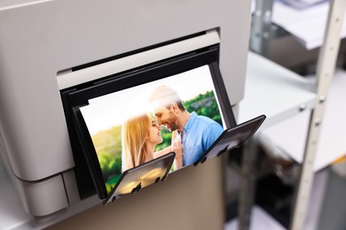 Photo of Modern printer with colorful photo indoors, closeup