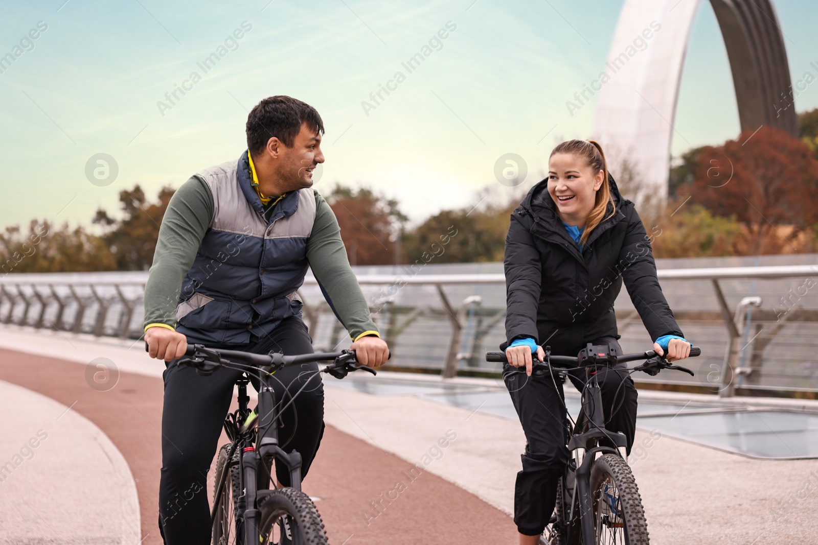 Photo of Beautiful happy couple riding bicycles and spending time together outdoors