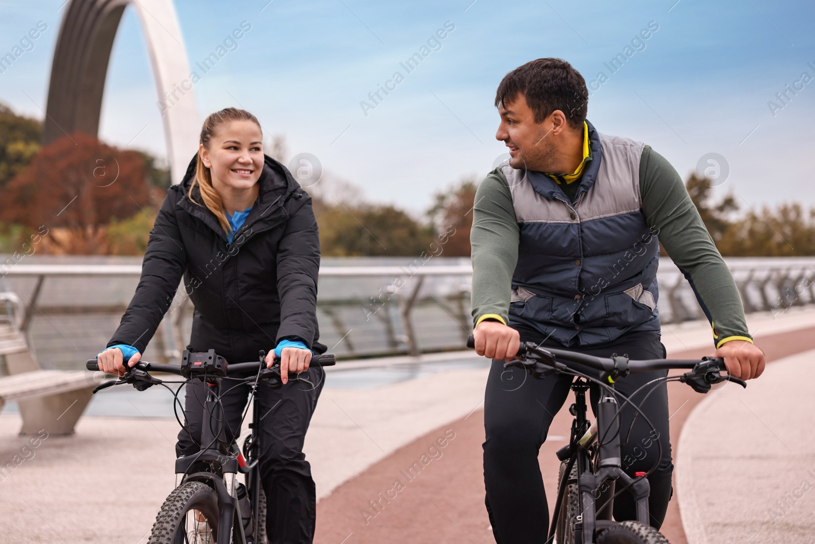 Photo of Beautiful happy couple riding bicycles and spending time together outdoors