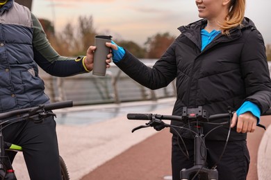 Photo of Couple with bicycles spending time together outdoors, closeup