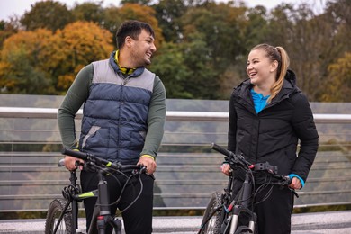 Photo of Beautiful happy couple with bicycles spending time together outdoors