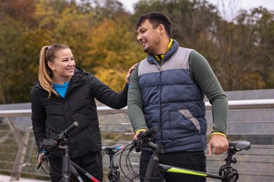 Photo of Beautiful happy couple with bicycles spending time together outdoors