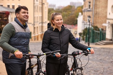 Photo of Beautiful happy couple with bicycles spending time together outdoors