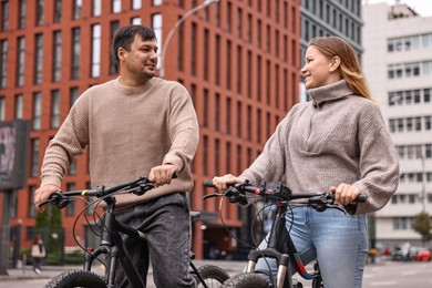 Photo of Beautiful happy couple with bicycles spending time together outdoors