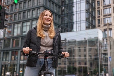 Photo of Woman with bicycle outdoors, low angle view. Space for text