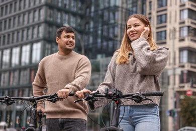 Beautiful happy couple with bicycles spending time together outdoors