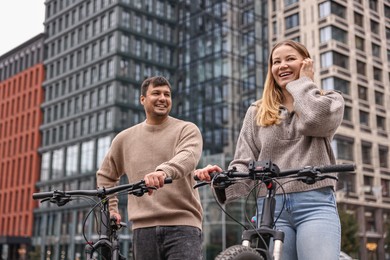 Photo of Beautiful happy couple with bicycles spending time together outdoors