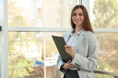 Portrait of banker with clipboard in office. Space for text