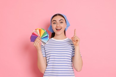 Photo of Portrait of young decorator with color palettes on pink background