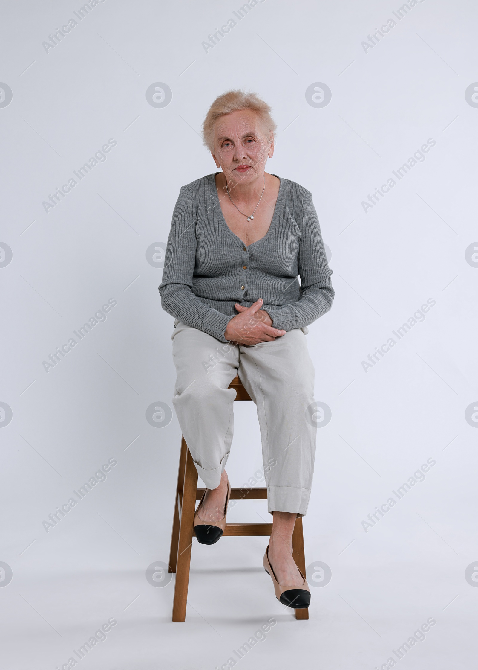 Photo of Senior woman on chair against white background