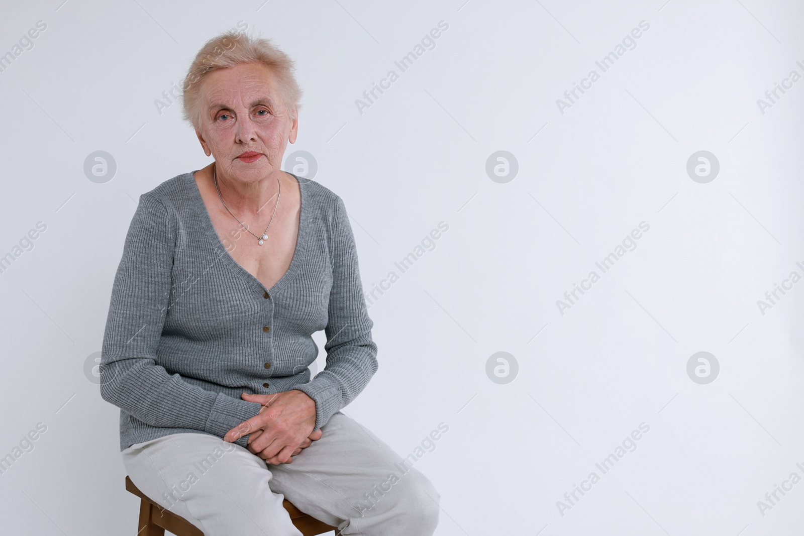 Photo of Senior woman on chair against white background. Space for text