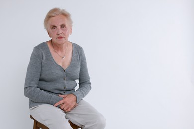 Photo of Senior woman on chair against white background. Space for text