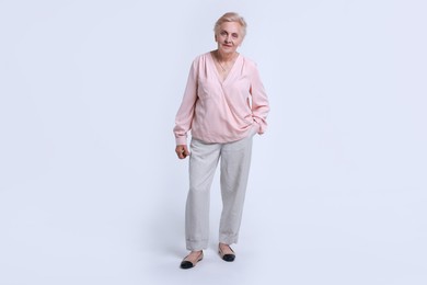 Photo of Full length portrait of senior woman on white background