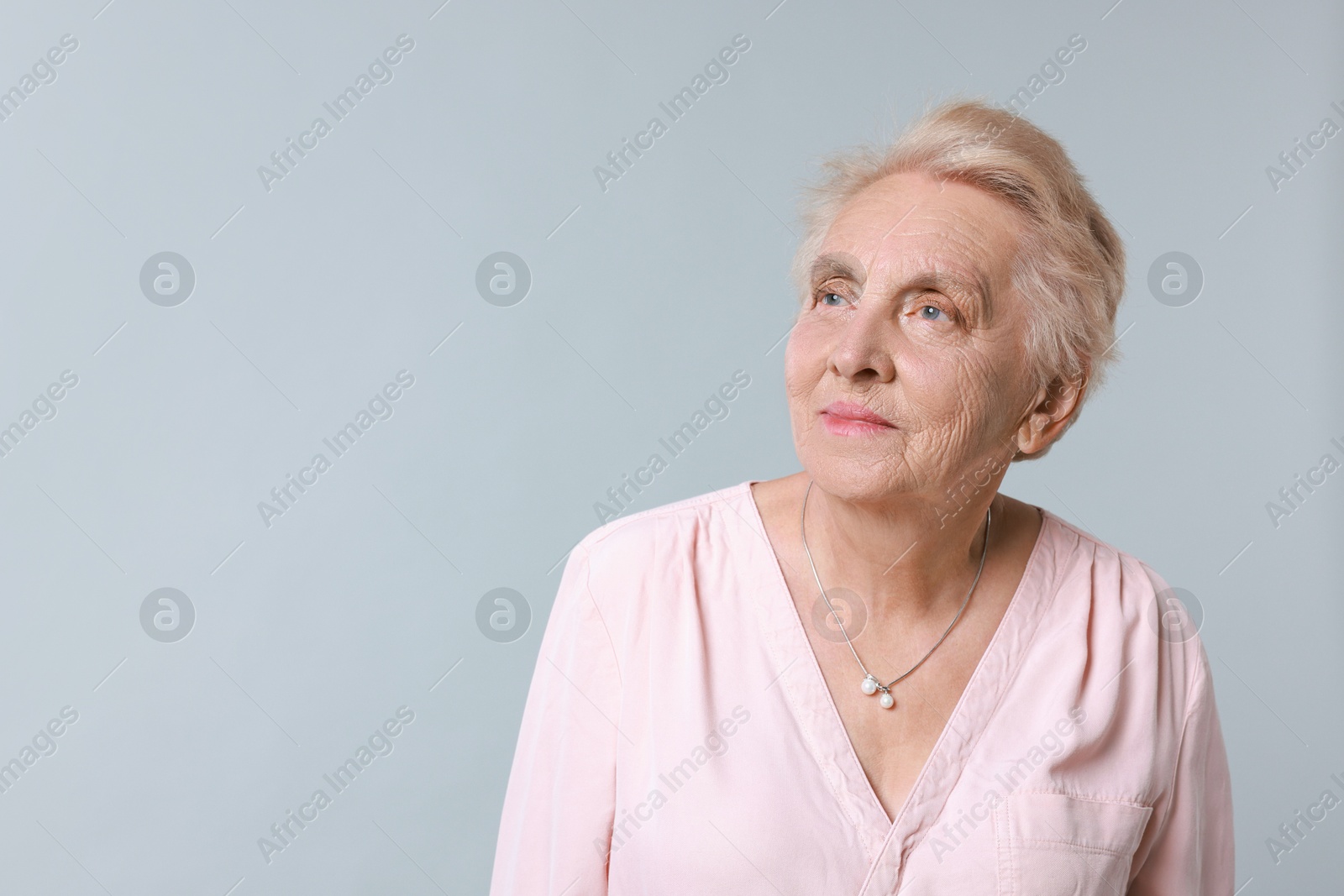 Photo of Portrait of senior woman on light background. Space for text