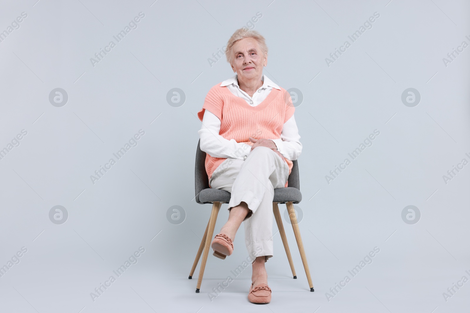 Photo of Senior woman on chair against light background