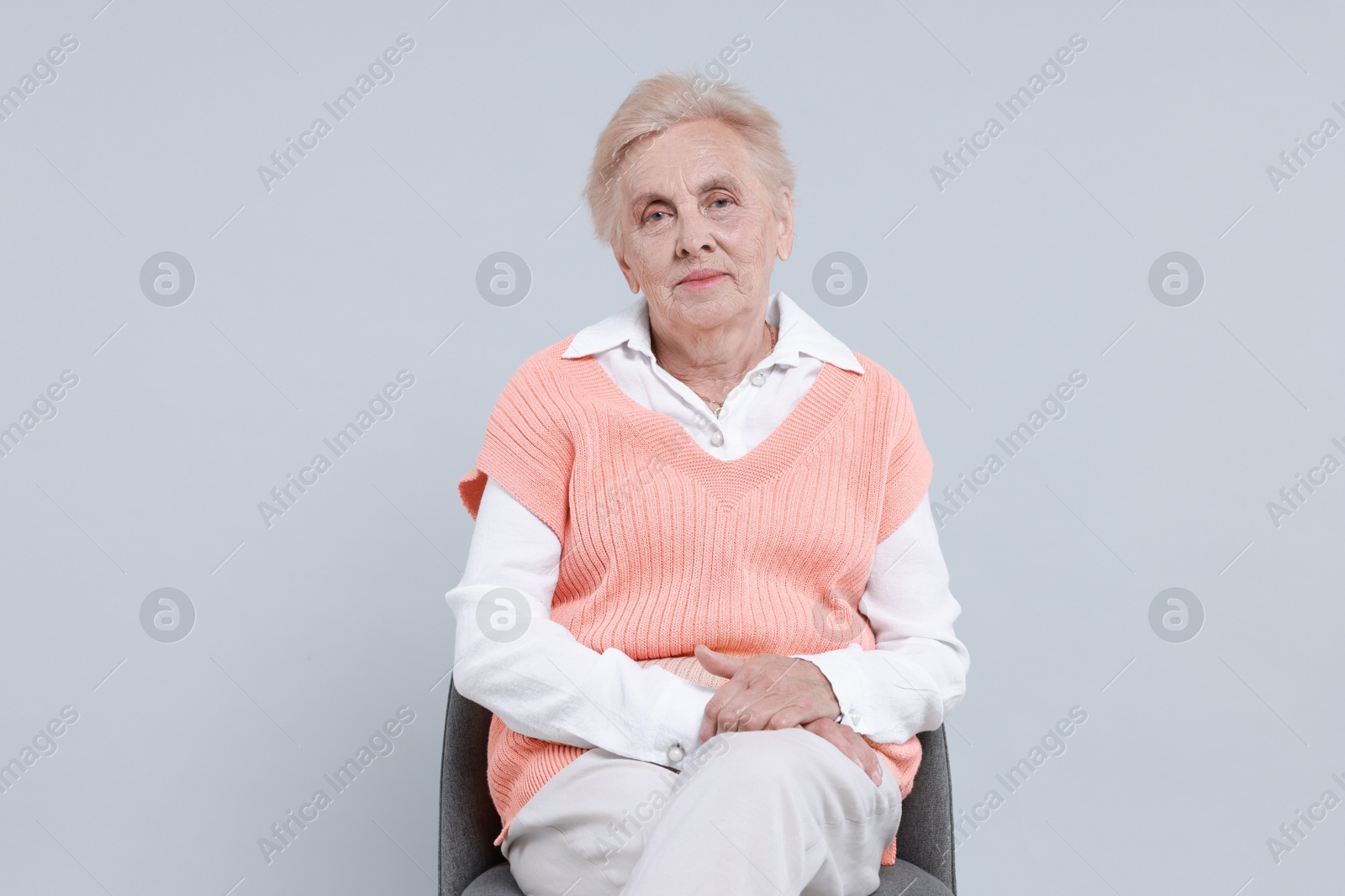 Photo of Senior woman on chair against light background