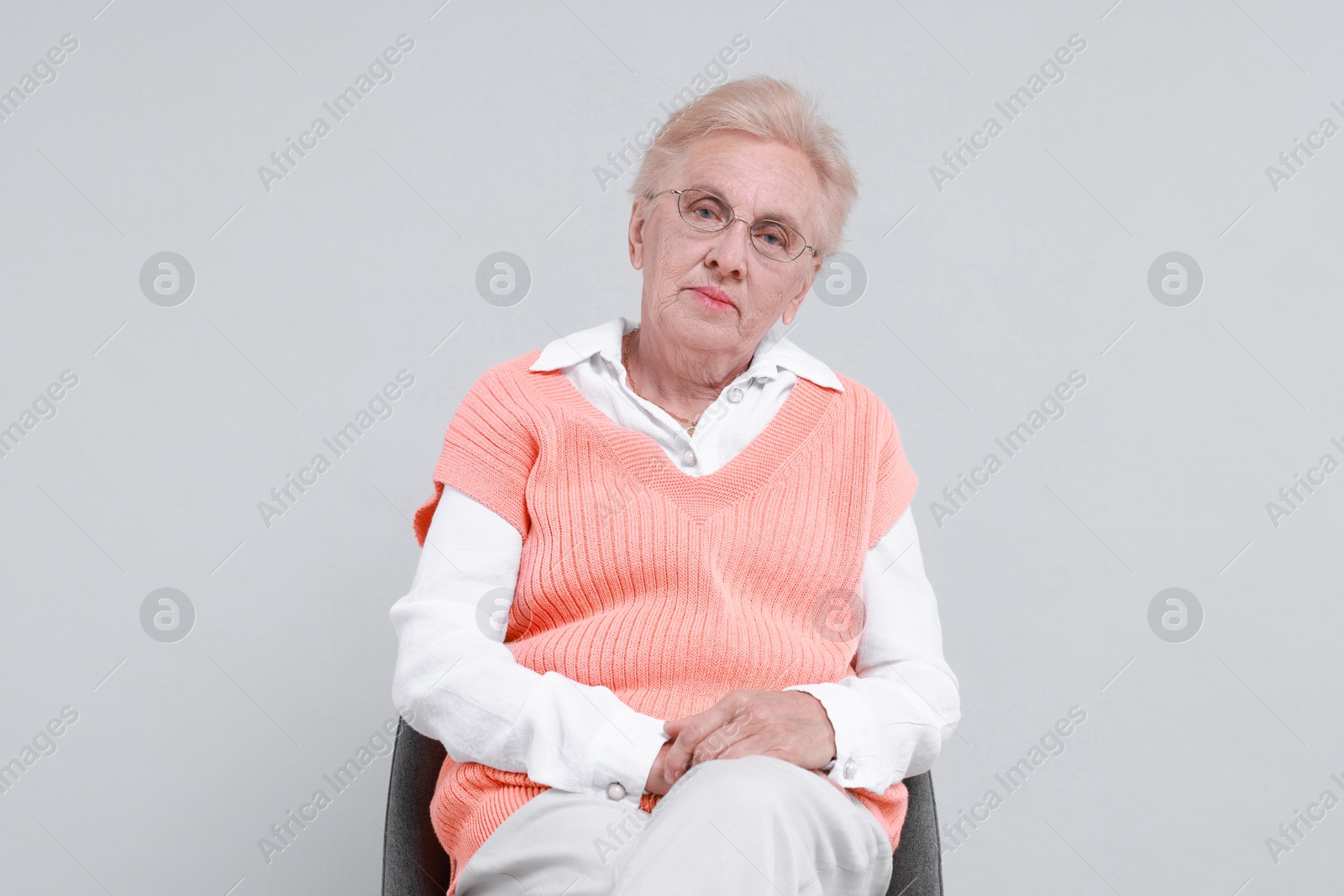 Photo of Senior woman on chair against light background