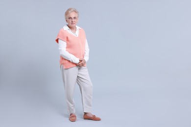 Photo of Full length portrait of senior woman on light background. Space for text