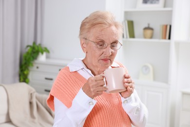 Photo of Senior woman with cup of drink at home