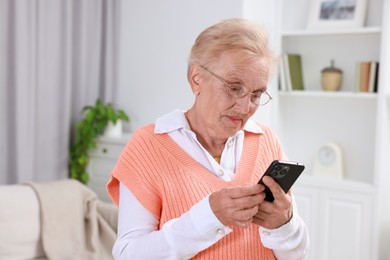 Photo of Senior woman using her smartphone at home