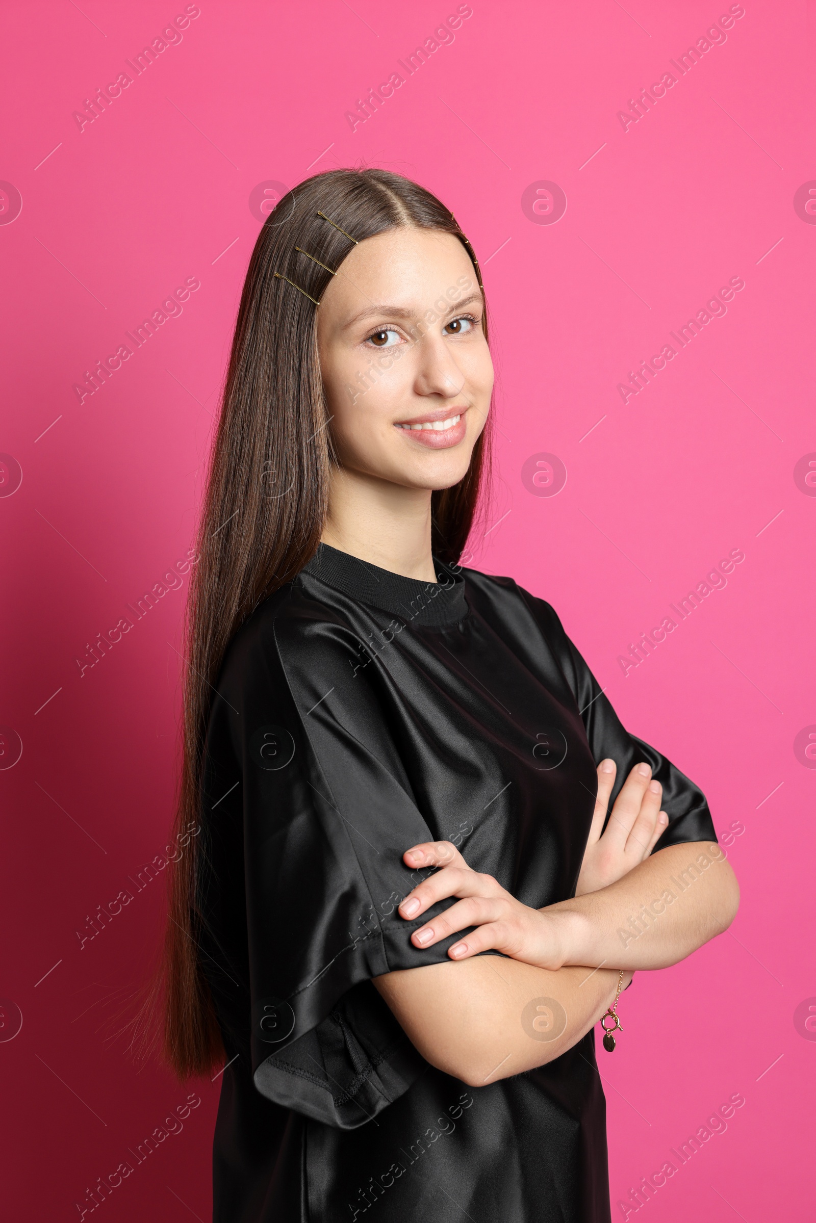 Photo of Teenage girl with stylish hair clips on pink background