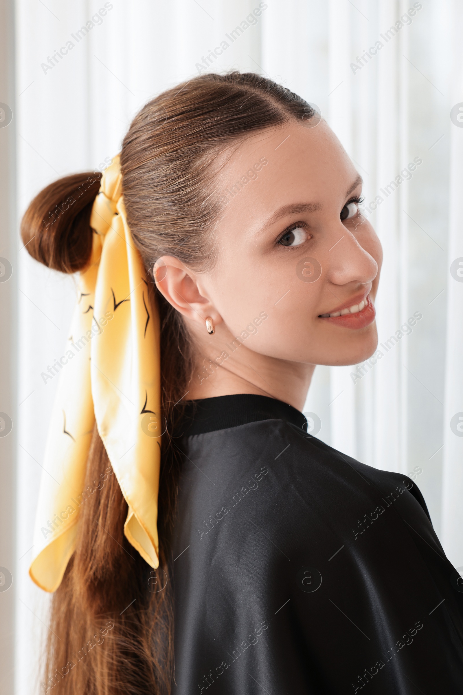 Photo of Teenage girl with long hair and stylish bandana indoors