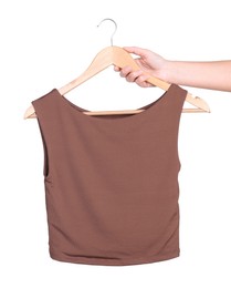 Photo of Woman holding hanger with brown top on white background, closeup