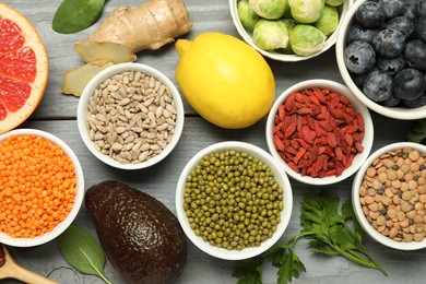 Photo of Superfood. Different healthy food products on grey wooden table, flat lay