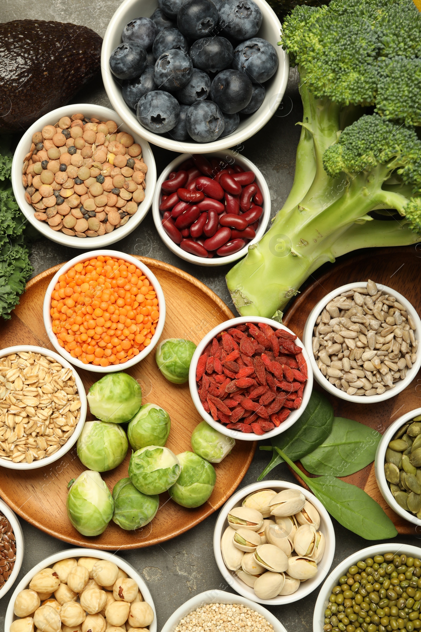 Photo of Superfood. Different healthy food products on grey table, flat lay