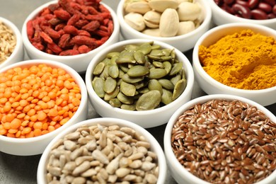 Photo of Different superfoods in bowls on table, closeup