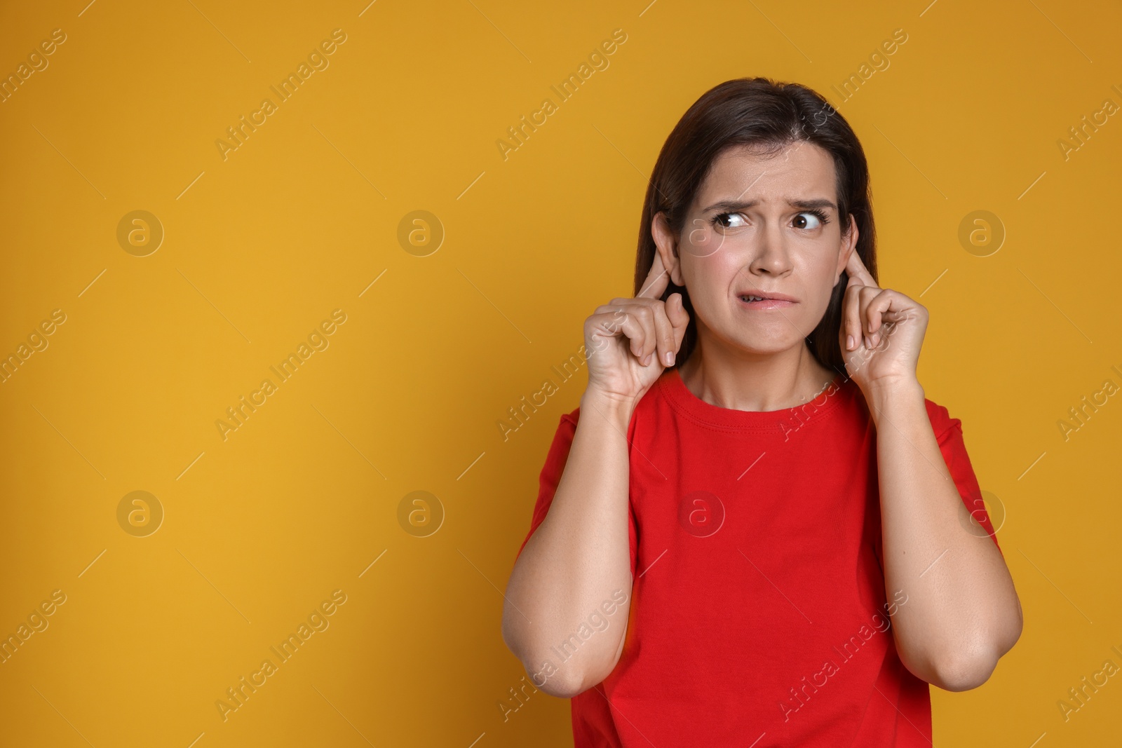 Photo of Woman showing hand to ear gesture on orange background, space for text