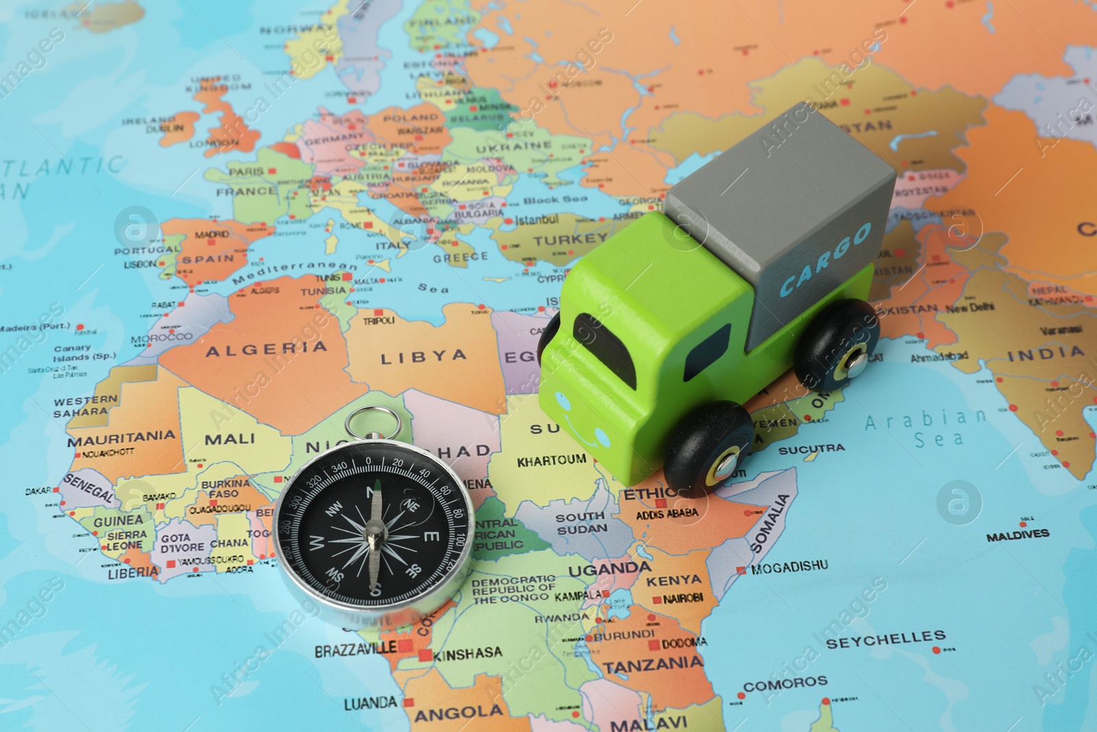 Photo of Toy truck and compass on world map. Logistics concept