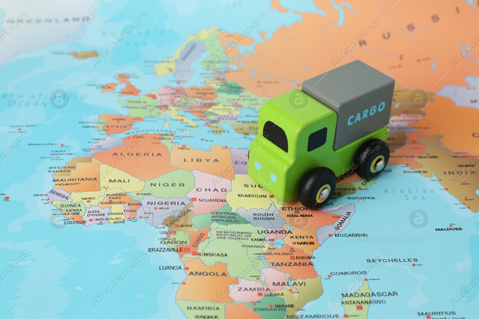 Photo of Toy truck on world map, closeup. Logistics concept