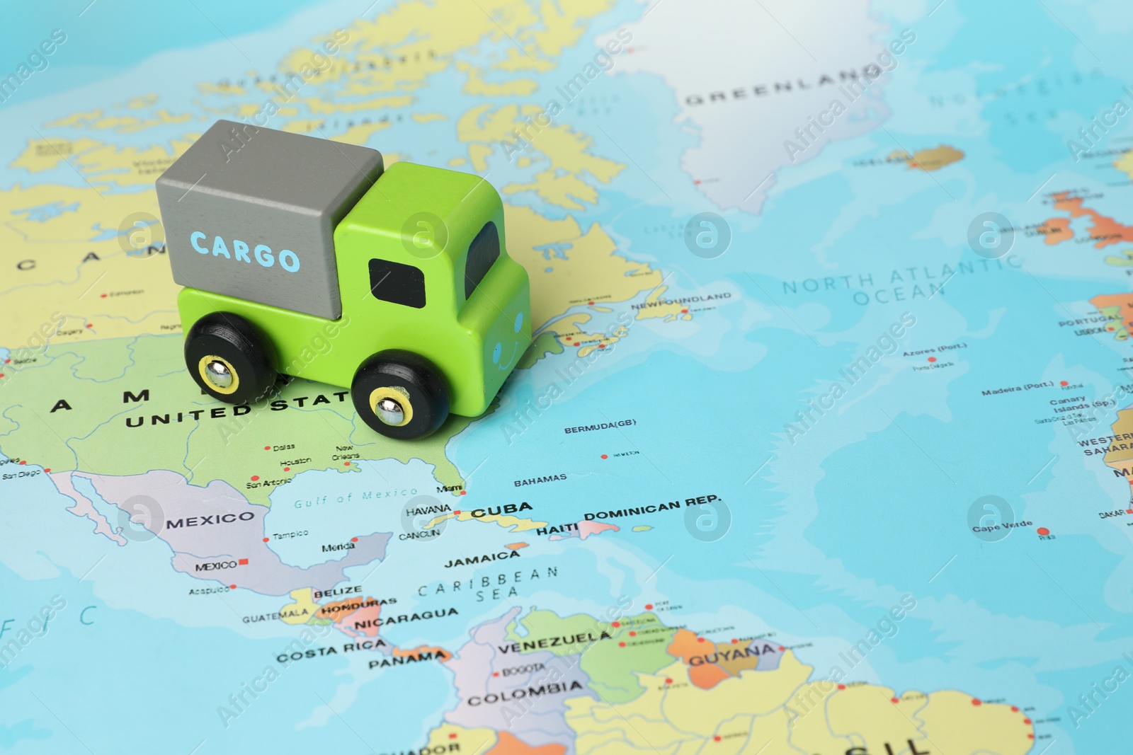 Photo of Toy truck on world map, closeup. Logistics concept