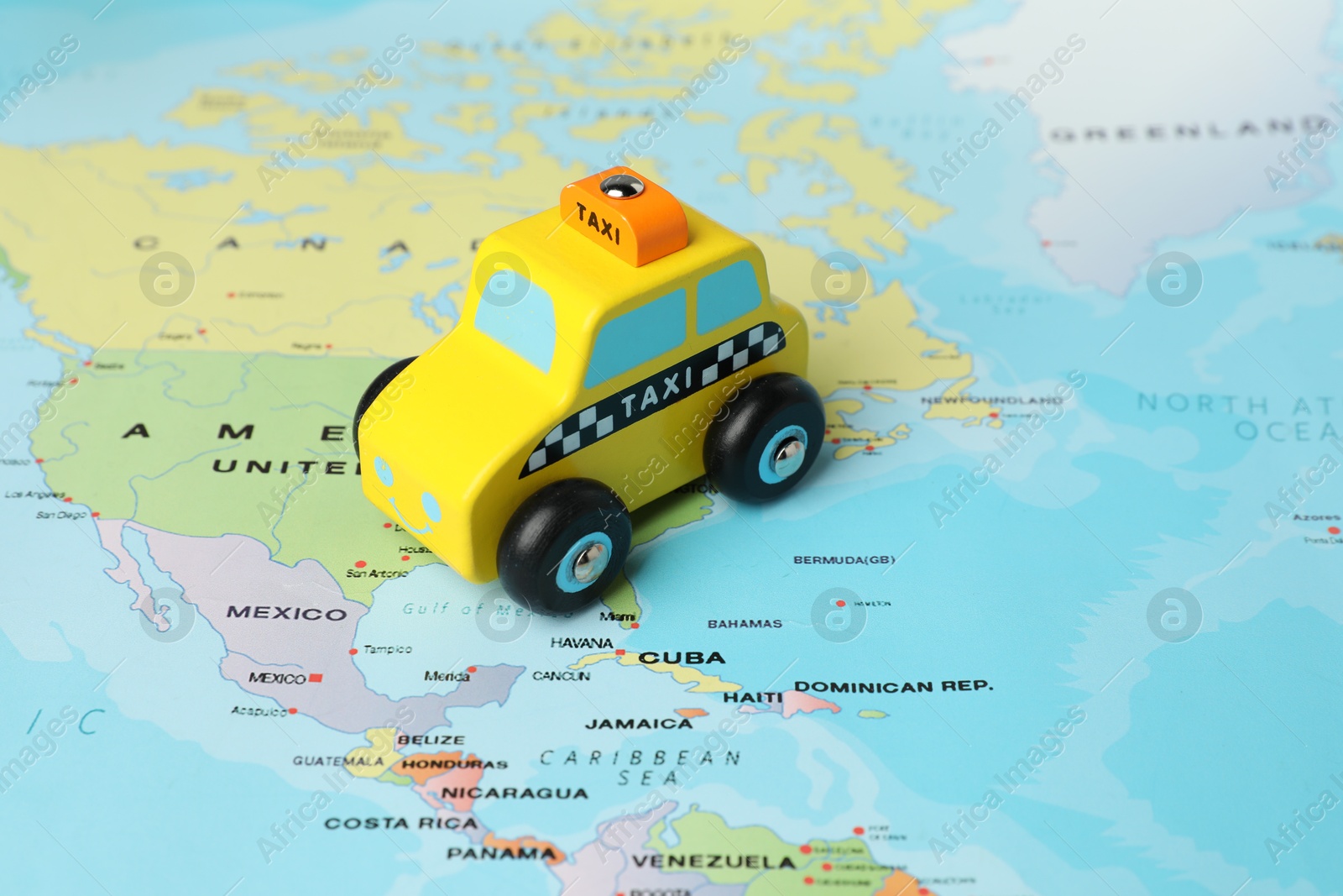 Photo of Yellow taxi car on world map, closeup