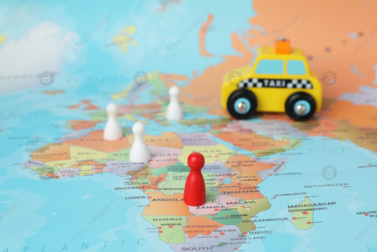 Photo of Yellow taxi car and human figures on world map. Road trip planning