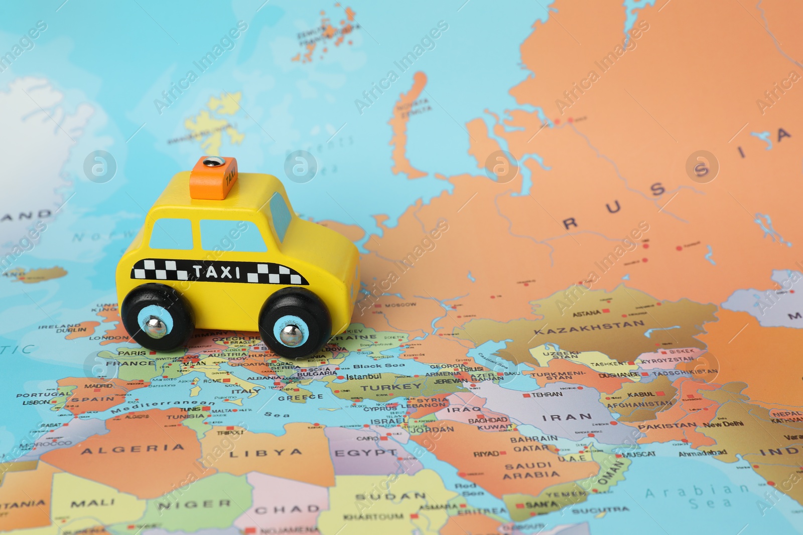 Photo of Yellow taxi car on world map. Road trip