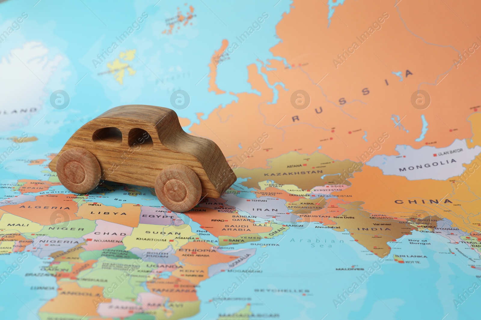 Photo of Wooden toy car on world map. Road trip